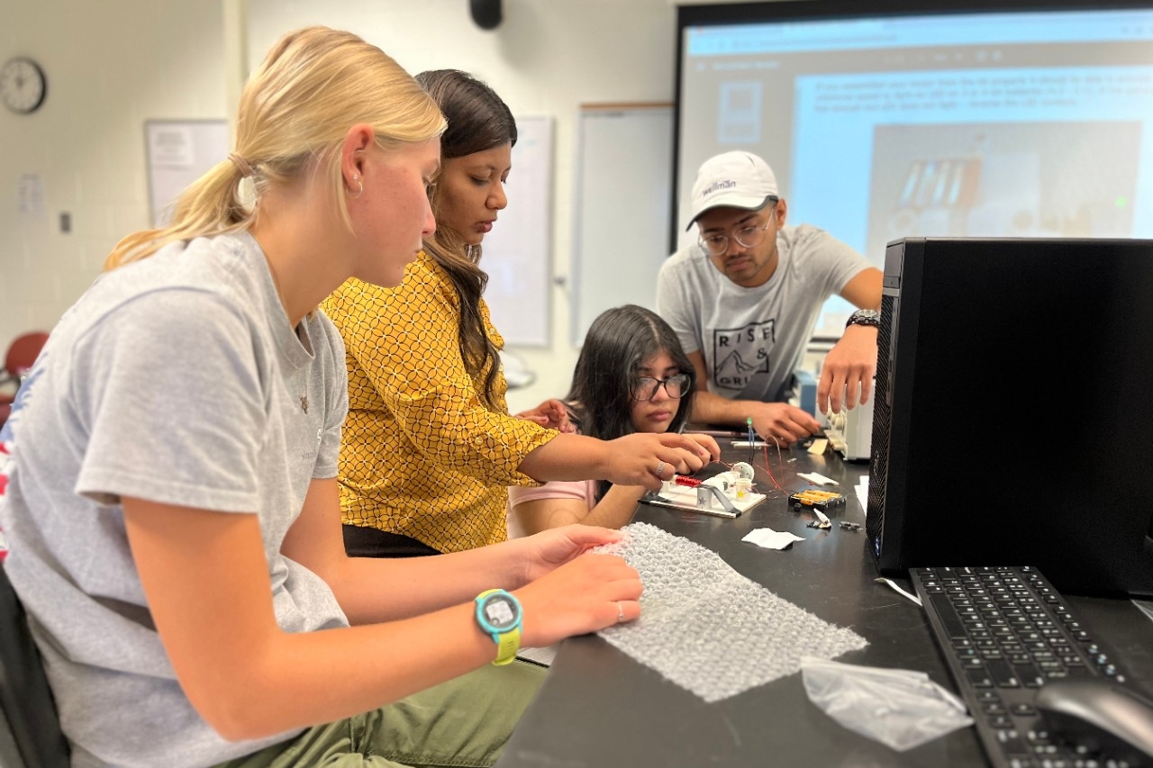 Teens doing activities with microcontrollers with the guidance of NKU faculty and student