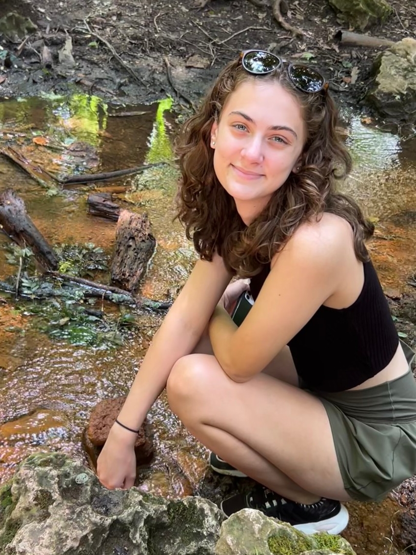 Tessa Sangermano Tessa Sangermano smiles while standing in a stream outside.