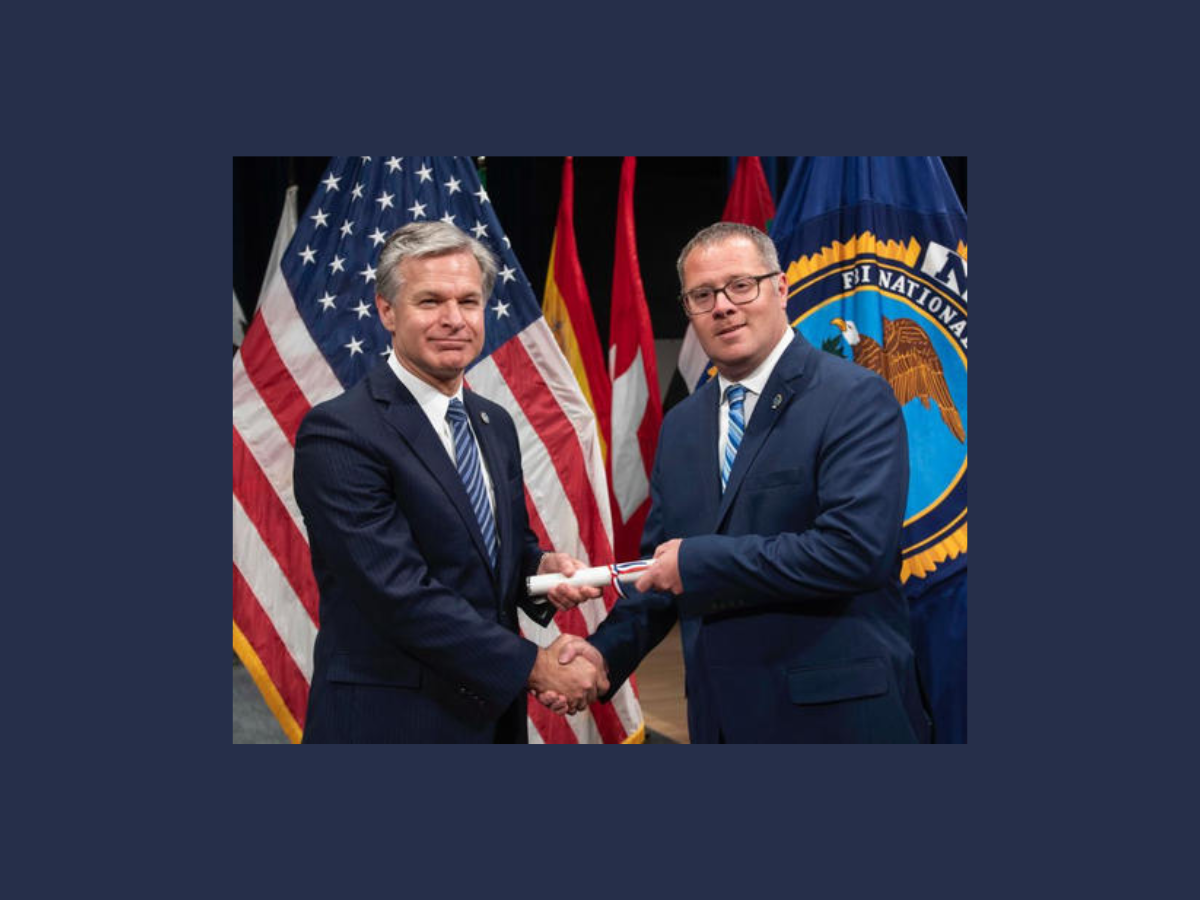 Christopher Wray and James Mills shaking hands