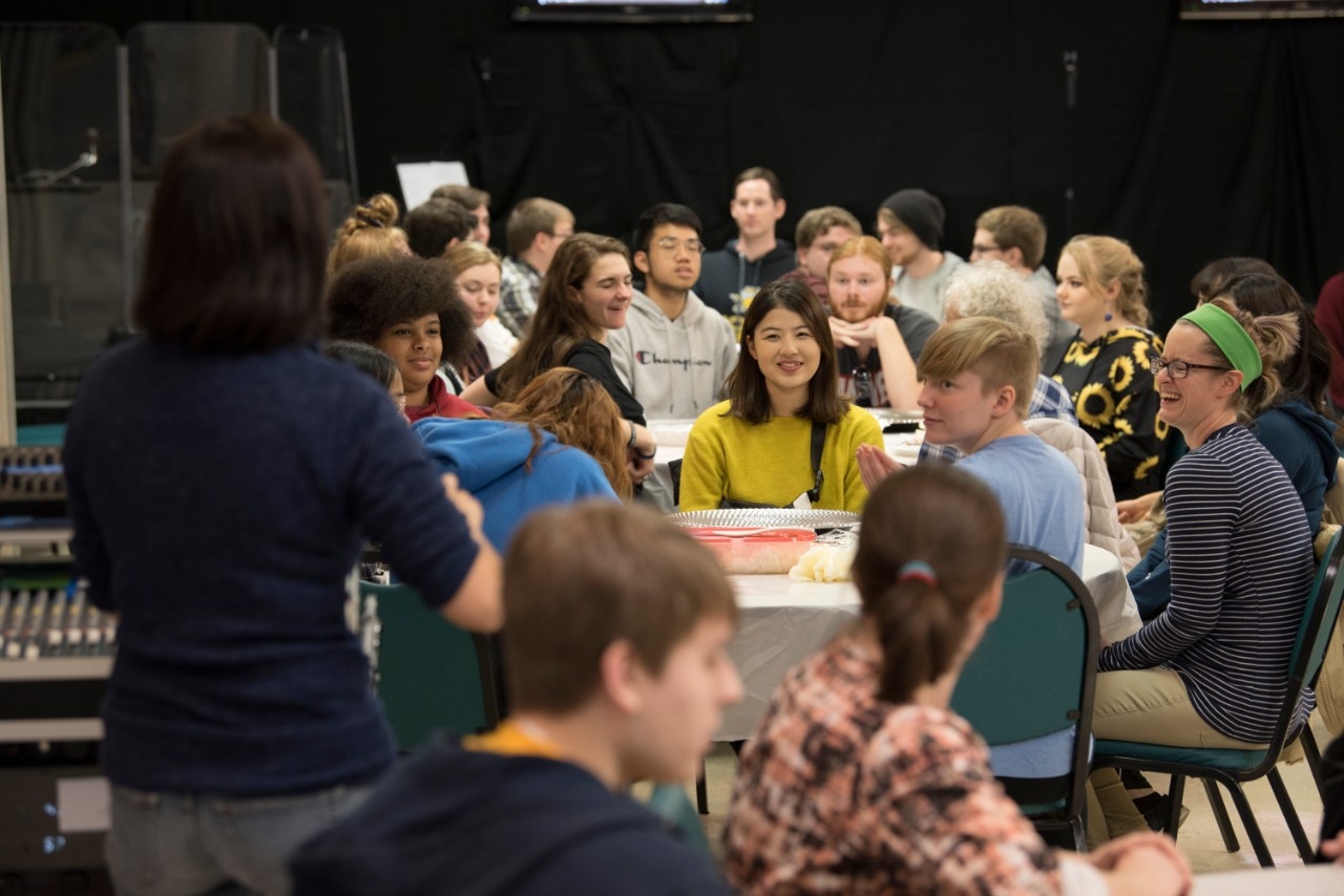 Japanese club students sitting at tables during a Sushi making event.